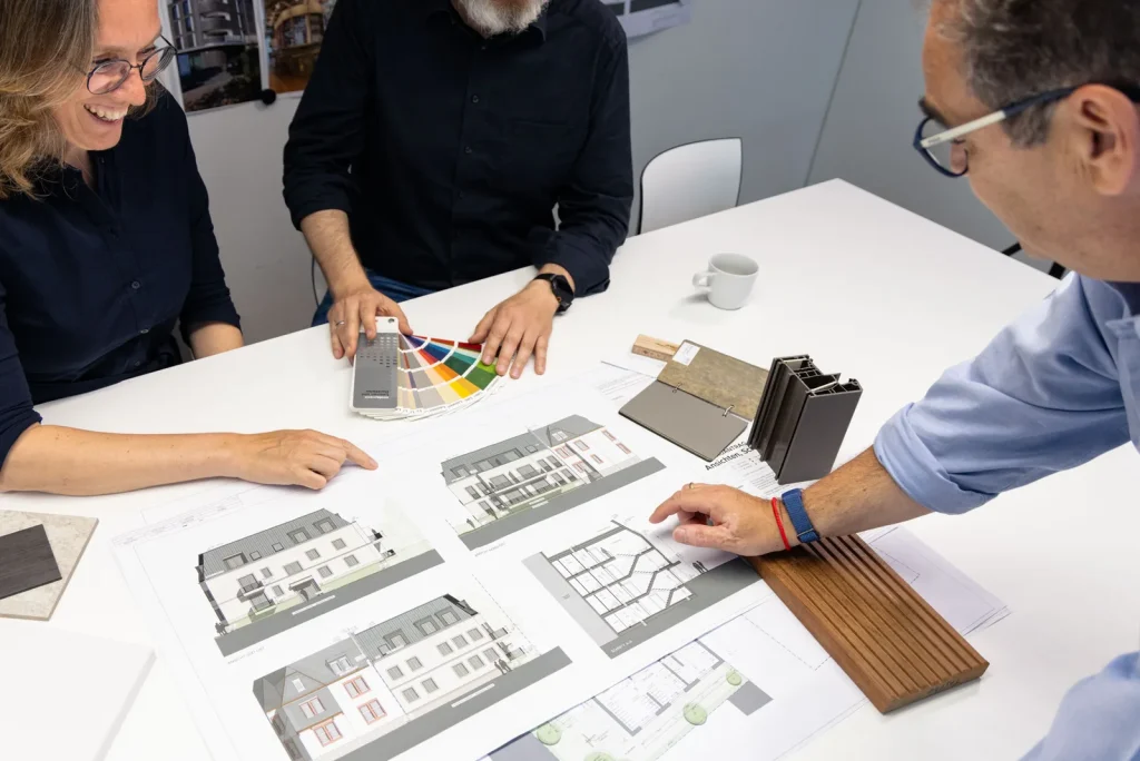 Besprechung von Ansichtsplänen mit Material- und Farbmustern im Büro von Main Werk Architekten